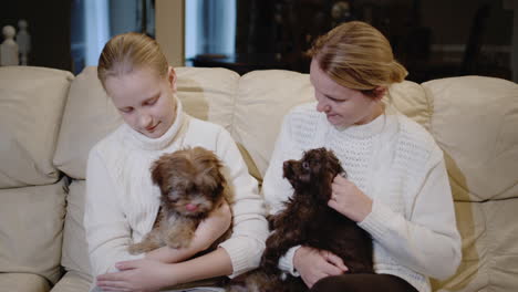 Mother-and-daughter-play-together-with-small-puppies,-relax-at-home