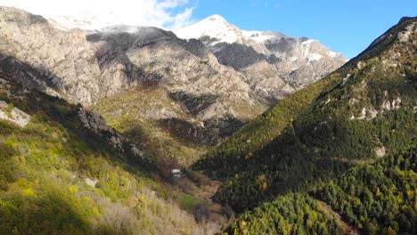 antena: hiperlapso entre dos montañas con el valle debajo y montañas cubiertas de nieve al fondo