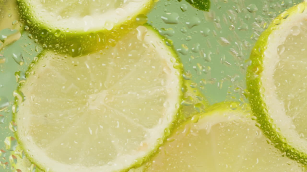 Lime slices in water with droplets