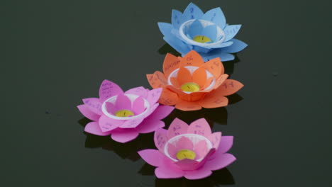 Gruppe-Von-4-Kerzen-Aus-Papier-In-Form-Einer-Lotusblüte,-Die-Nachts-Auf-Dem-Flusswasser-Schwimmt,-Zur-Jährlichen-Feier-Des-Buddhistischen-Vesak-Festes-In-Südostasien