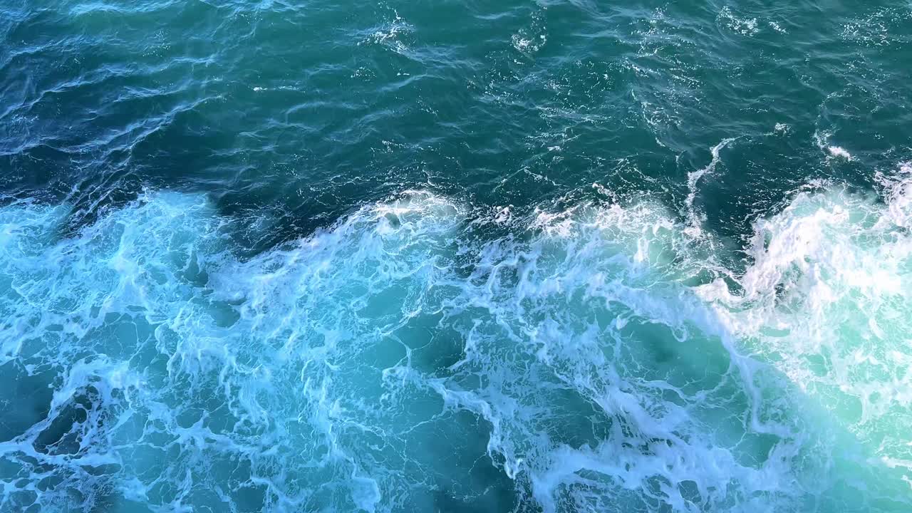 Foamy white water wake at the side of a ship.