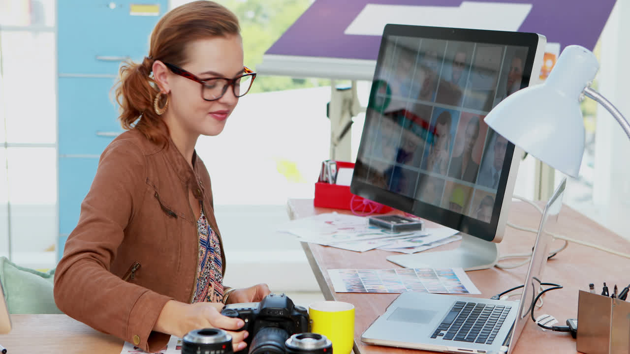 mujer ejecutiva revisando fotografía capturada en su escritorio 4k