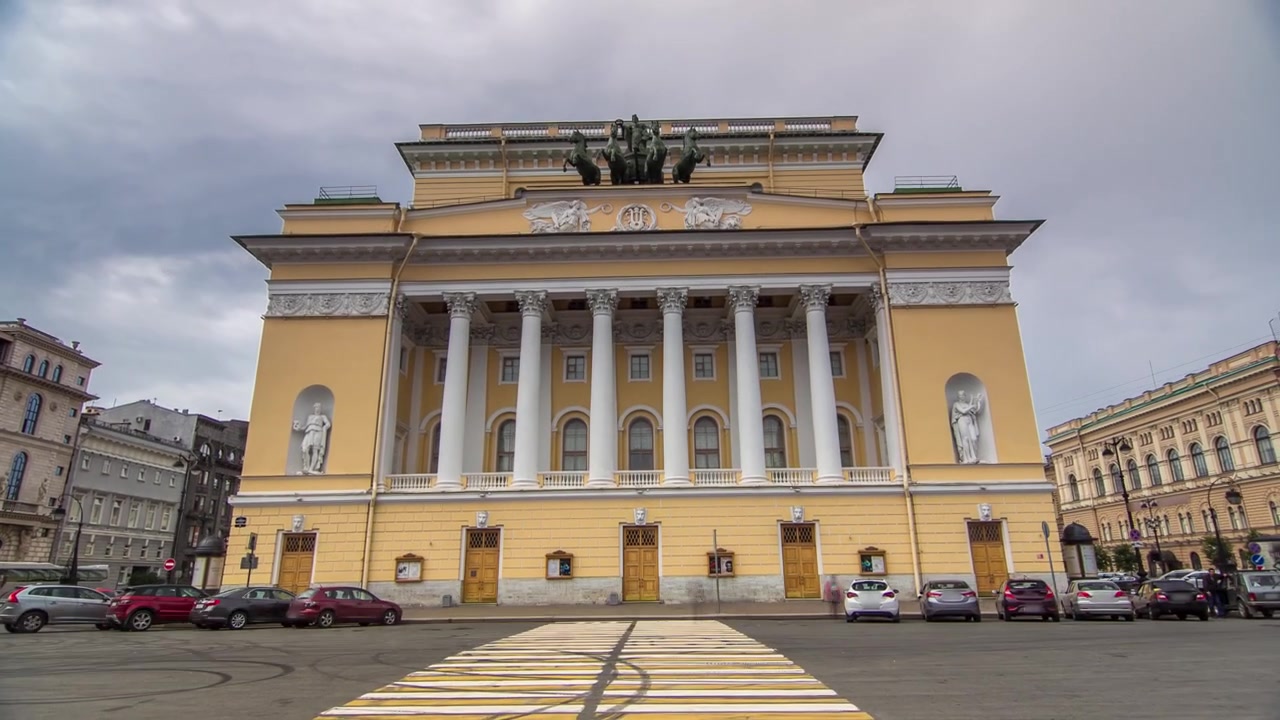 La facciata posteriore del Teatro Alexandrinsky a San Pietroburgo prende vita in un timelapse hyperlapse, sullo sfondo di un cielo coperto. Incrocio stradale.