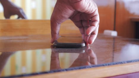 a person picking up a phone from a table