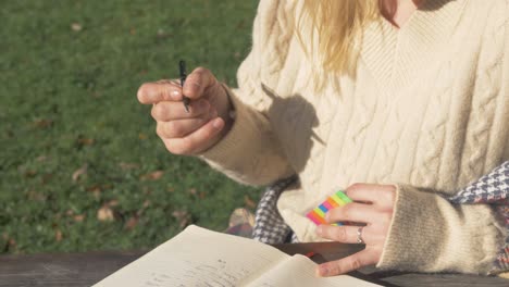 eine frau buchmarkiert eine seite, während sie im freien studiert