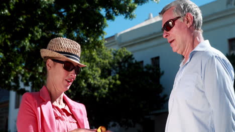 Happy-couple-meeting-and-woman-showing-her-purchases-to-partner