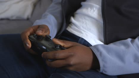 black male playing video game intensely in lounge room