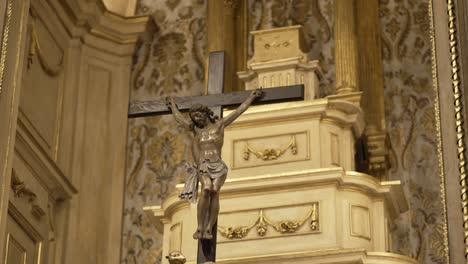 Crucifix-statue-of-Jesus-on-the-cross-in-an-ornate-church-altar,-symbolizing-faith-and-devotion