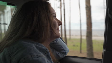 red haired woman enjoys a drive through the countryside next to the lake 1