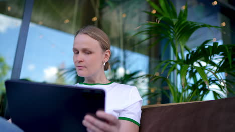 woman focused on tablet outdoors