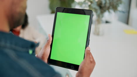 man holding a tablet with a green screen