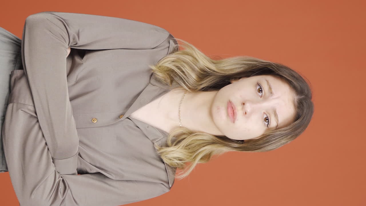 지루함으로 호소하고 숨을 쉬는 젊은 여성의 수직 비디오.