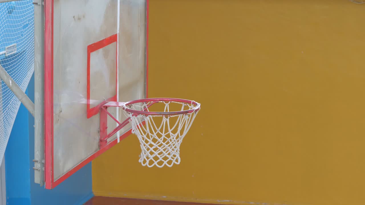 la pelota de baloncesto vuela a la canasta en el viejo salón de deportes.