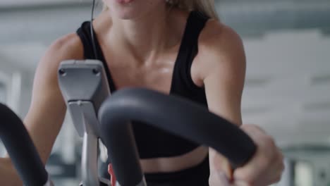 Tilt-up-video-of-tired-woman-working-out-with-exercise-bike