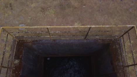 toma aérea a vista de pájaro de un túnel de agua y una cámara inclinada hacia un estanque y montañas al fondo, boquete, chiriquí, panamá.