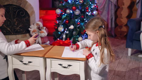 little girls during christmas time. happy little girls drawing picture for santa claus