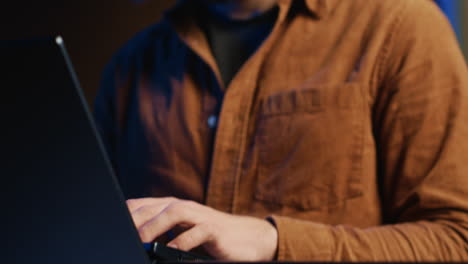 programmer concentrating on writing binary code scripts on laptop, close up