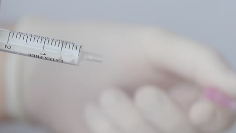 hand removes hypodermic needle from a syringe - medical concept - close up