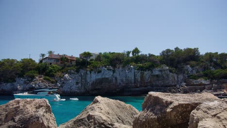 Mallorca:-Vista-Lateral-De-La-Playa-Del-Resort-En-Cala-Liombards-En-La-Isla-De-Mallorca,-España,-Europa-|-Barco-Cerca-De-Acantilados