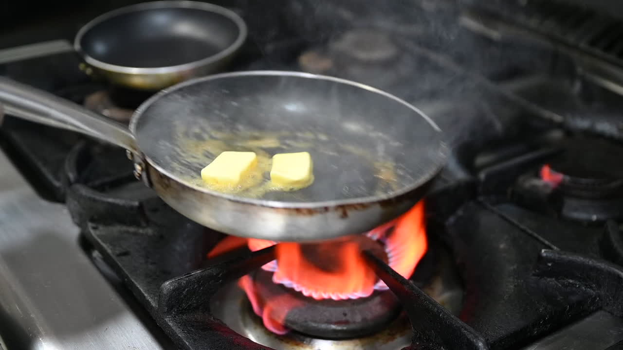 Melting the butter in a saucepan on the gas stove of a restaurant kitchen