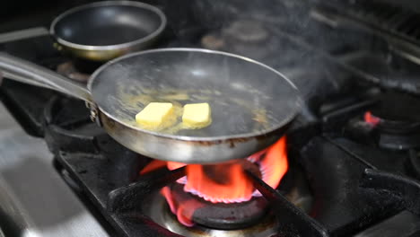 melting the butter in a saucepan on the gas stove of a restaurant kitchen