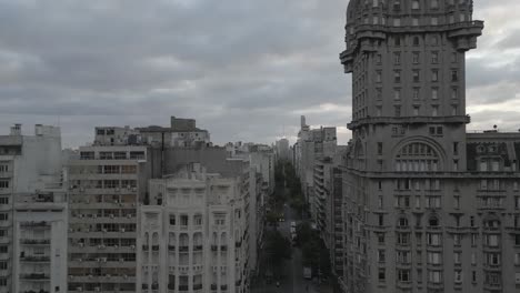 drone fly close to palacio salvo in montevideo uruguay cityscape and avenida 18 julio main road in city downtown with traffic cars and skyscraper building