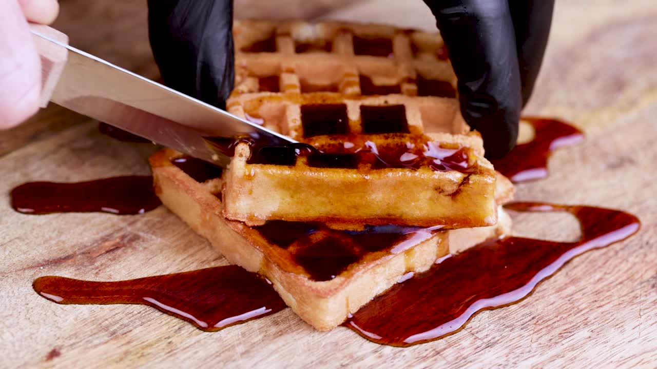 cutting soft waffles with bee honey during dessert cooking