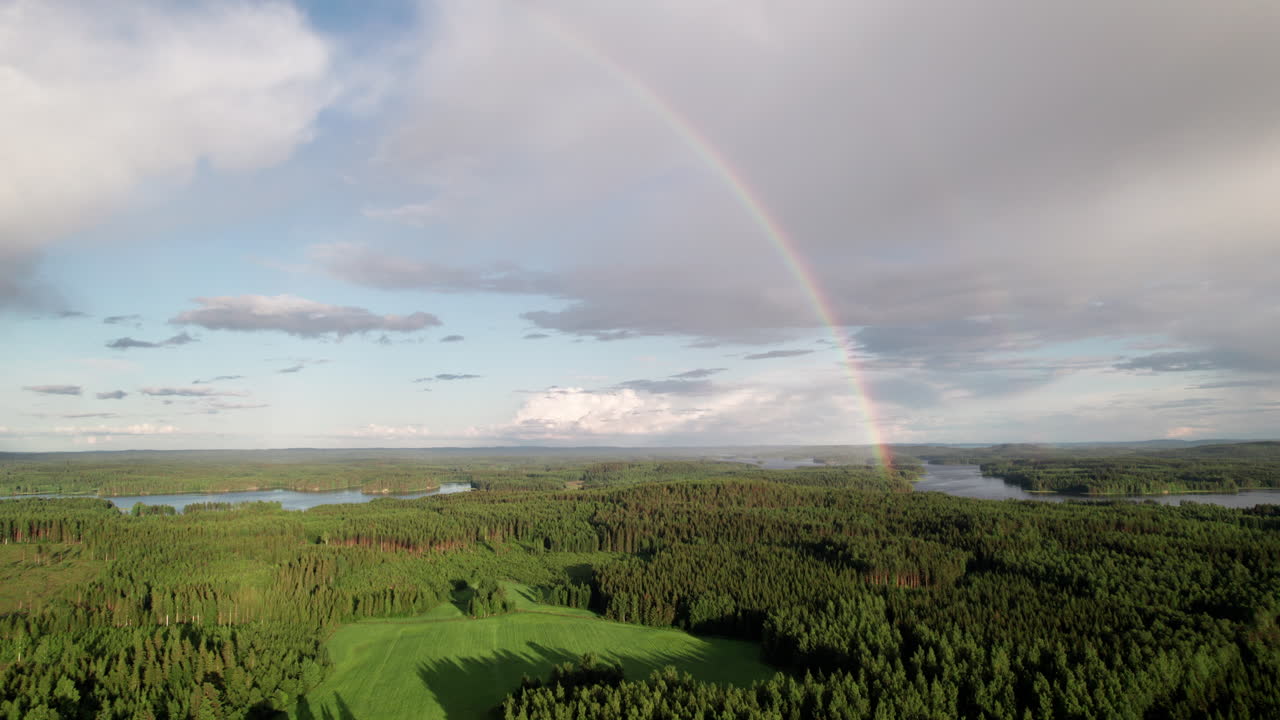 impresionante arco iris sobre un hermoso paisaje sereno de bosque y lago en finlandia, cerca de kuopio, la cámara se eleva