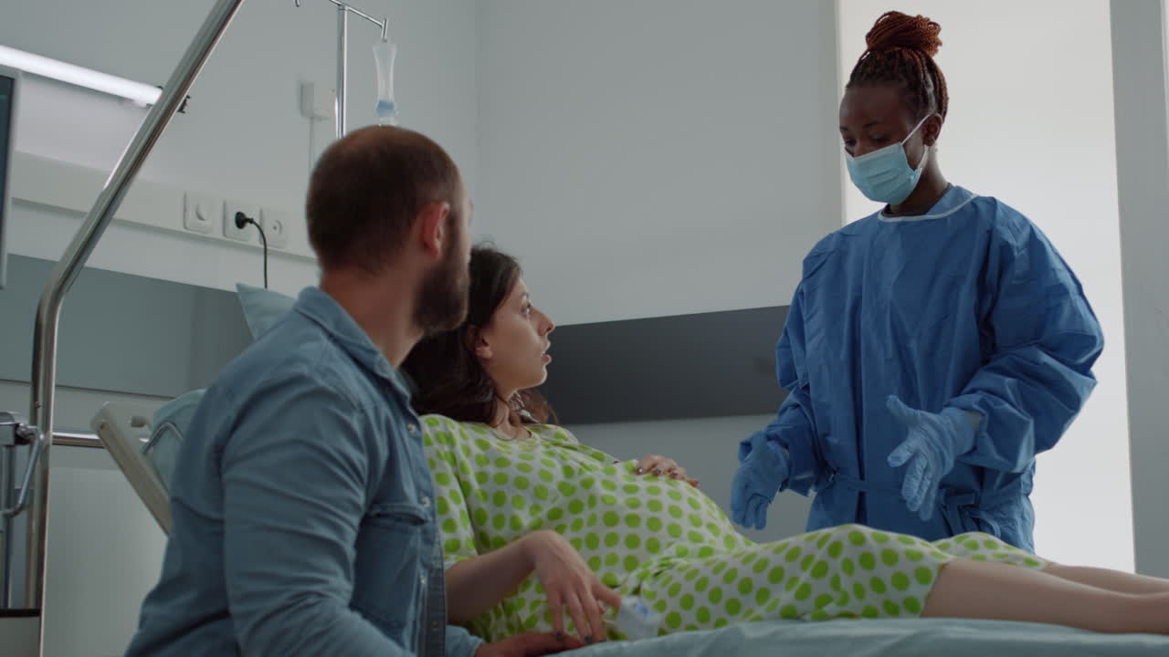 Patient with baby bump sitting in hospital ward bed