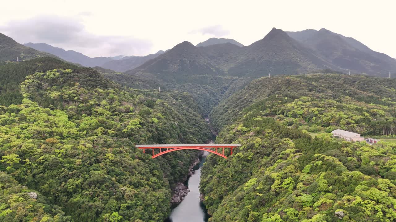 Red Bridge Over River in Mountainous Landscape