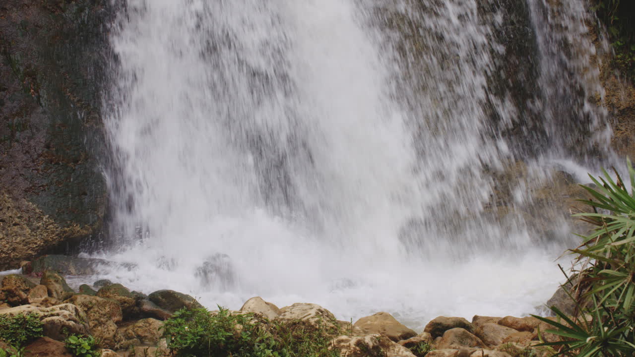 agua que fluye de una cascada en un acantilado en la selva tropical de puerto rico - estática
