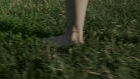 close-up of a barefooted woman walking in the grass