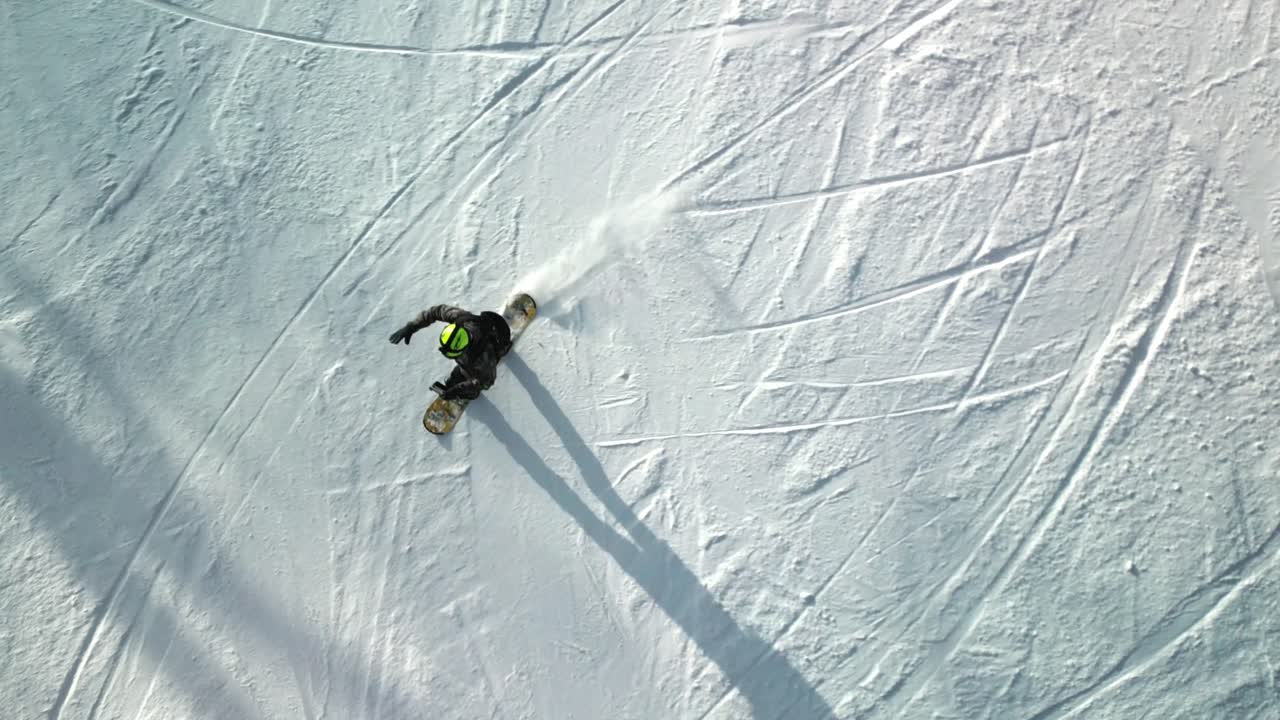 top down aerial footage of a snowboarder carving down Yabuli resort's slopes with impressive skill