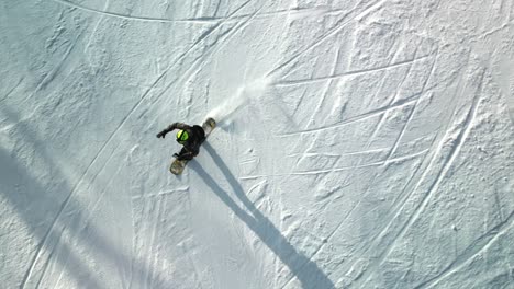 top down aerial footage of a snowboarder carving down yabuli resort's slopes with impressive skill