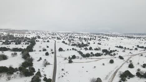 descending drone aerial view of snow covered countryside, fields and road, israel