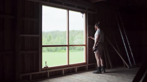 Hombre-Instalando-Un-Alféizar-De-Madera-Dentro-De-La-Casa-En-Indre-Fosen,-Noruega