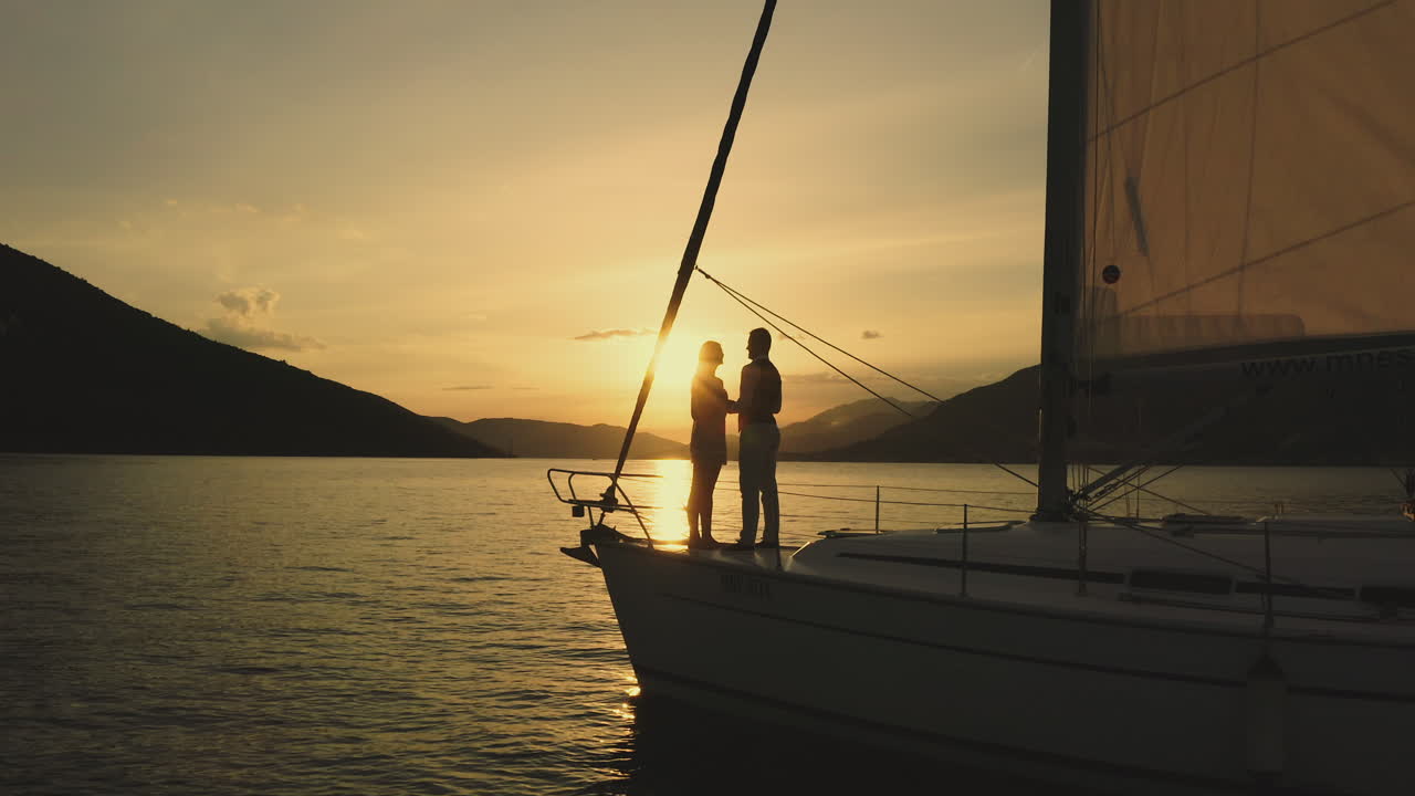 пара наслаждается закатом на яхте.