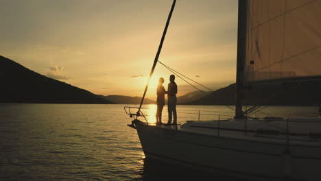 una pareja disfrutando de la puesta de sol en un yate