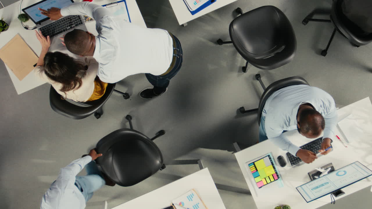 Vertical Video Top down view zoom in of staff consulting on project reports and data in office