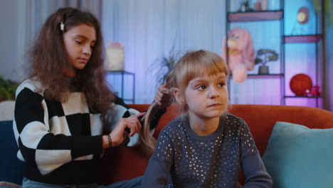 adolescentes y hermanas pequeñas niños niños usando peines cepillado hacer peinado peinado en casa sala de juegos