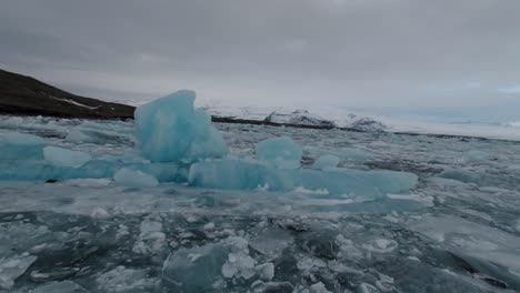 aerial fpv shot of frozen glacial lake in iceland