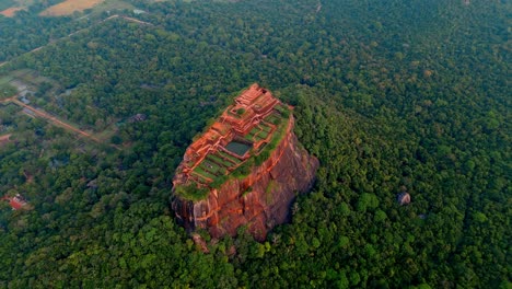 a breathtaking aerial view of sigiriya rock at dawn, with the ancient fortress illuminated by the soft first light of the day.