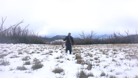 Un-Explorador-De-Montañas-Vestido-Como-Alguien-Del-Siglo-XIX-Camina-Por-Un-Paisaje-Montañoso-Nevado