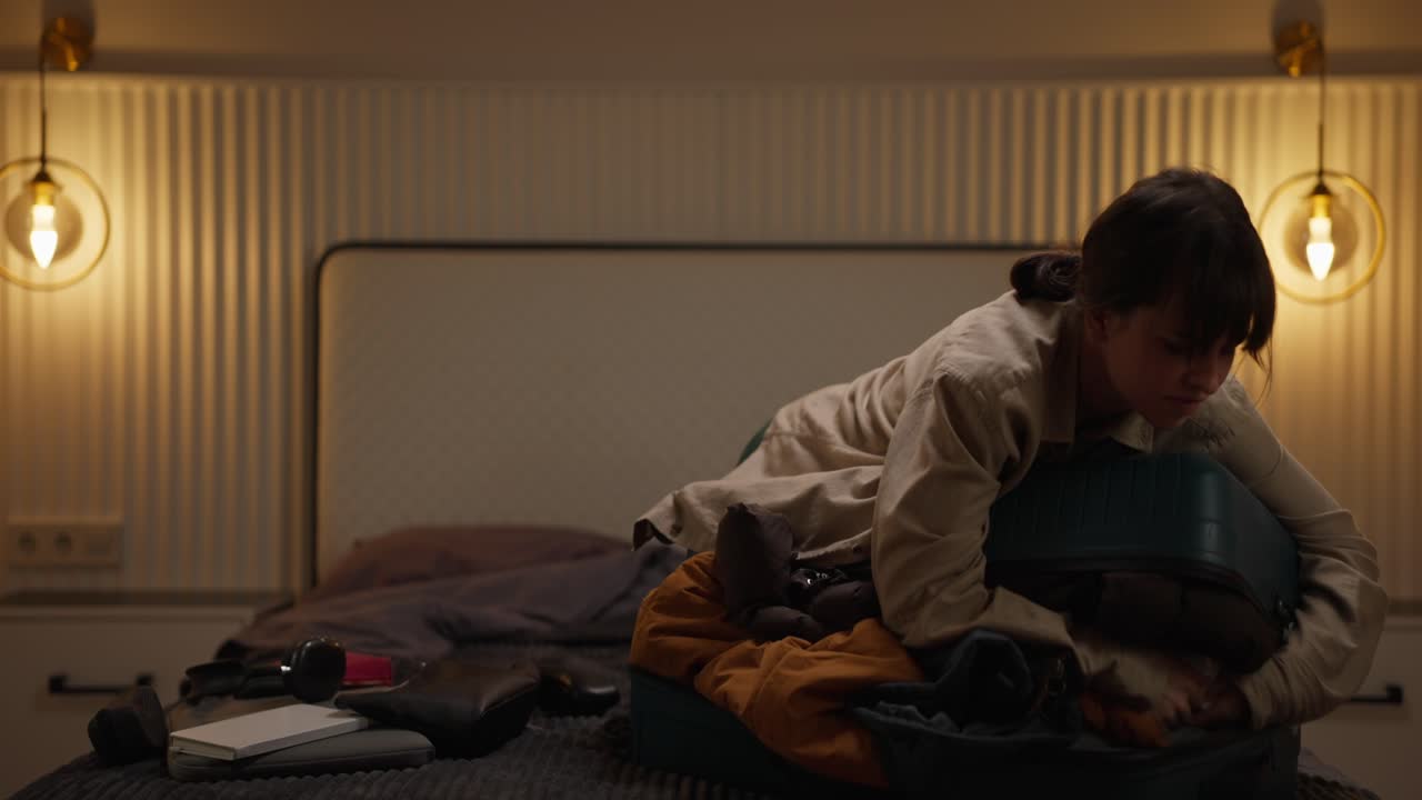 Valigia di imballaggio della donna sul letto