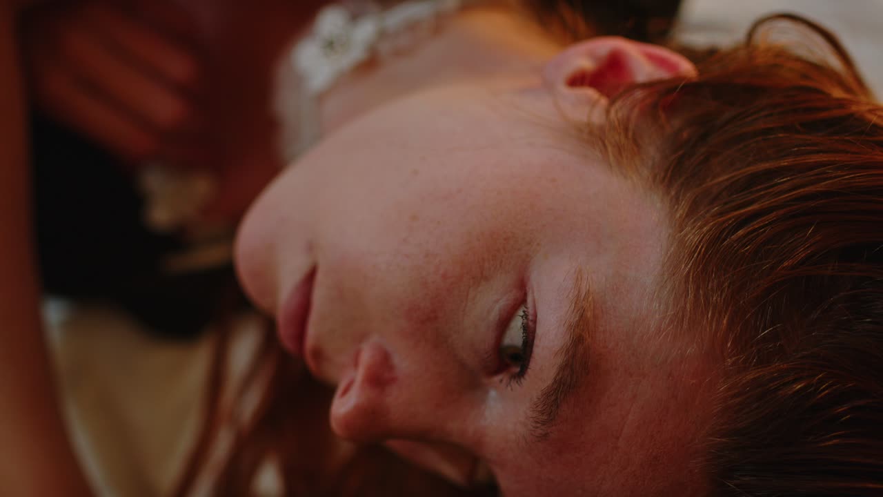 cerca de una hermosa mujer pelirroja en la cama abriendo los ojos y mirando a la cámara