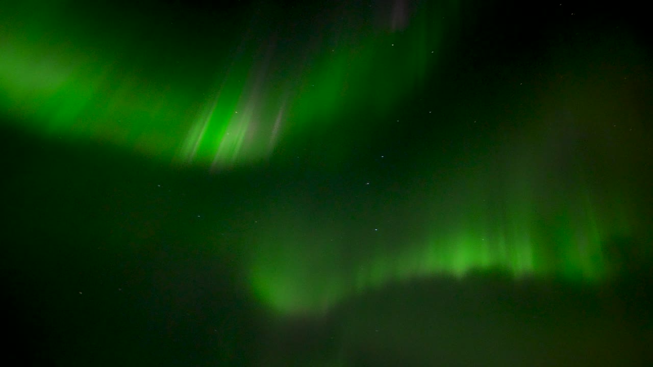aurora boreal de color verde de rápido movimiento en el cielo oscuro sobre la isla de islandia por la noche - portátil de abajo hacia arriba