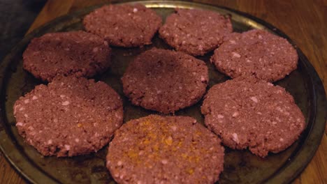 plant based impossible meat burger vegan patties un-cooked being prepped and seasoned on metal baking pan for grilling - in cinema 4k