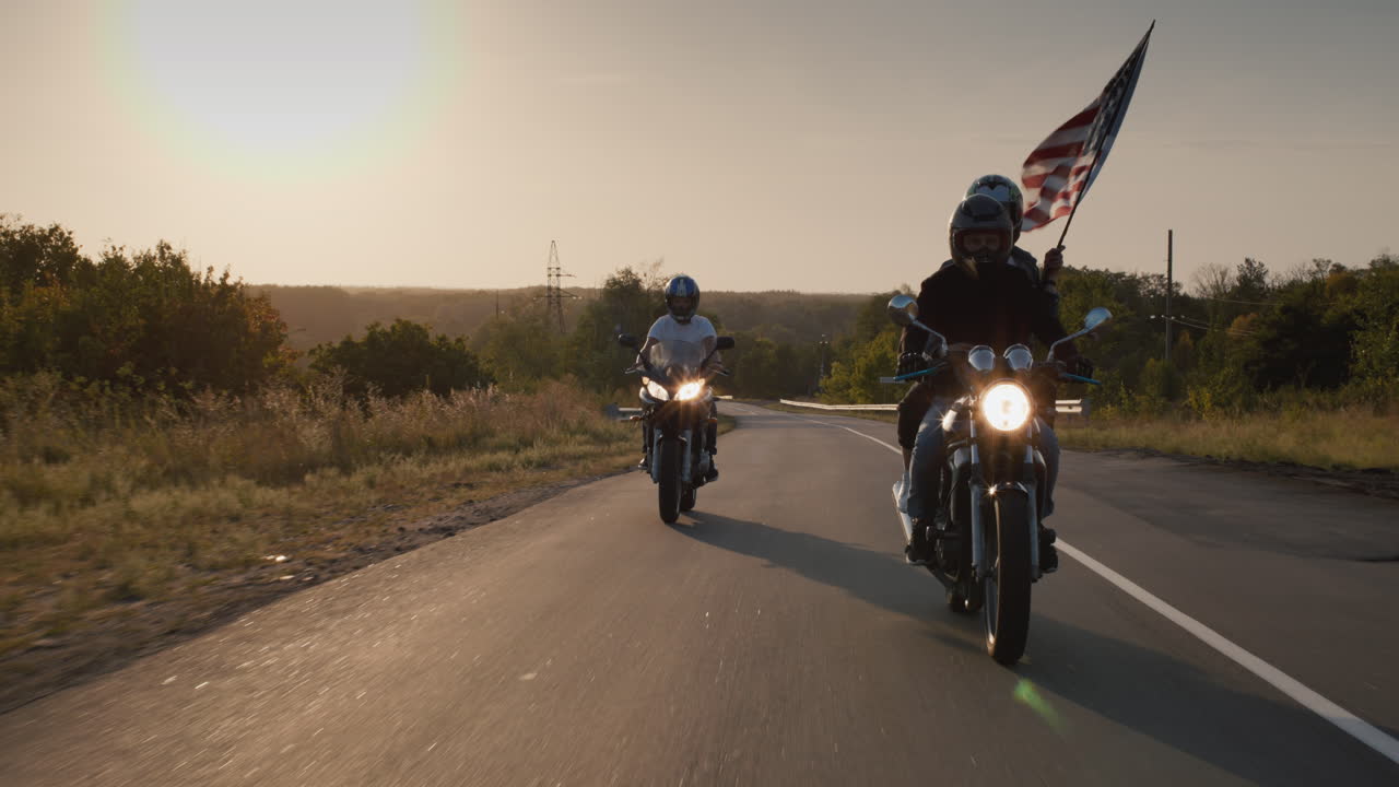 un grupo de ciclistas recorre la carretera al atardecer