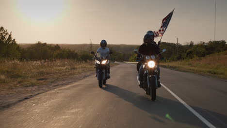 a group of bikers rides on the highway at sunset