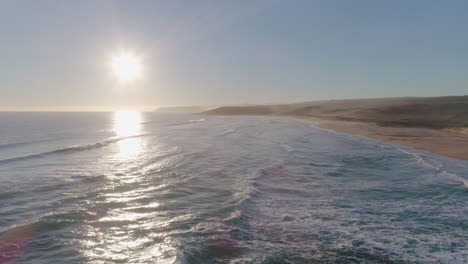 fotografía aérea al atardecer sobre una playa mientras las olas chocan contra la costa en el sur de australia